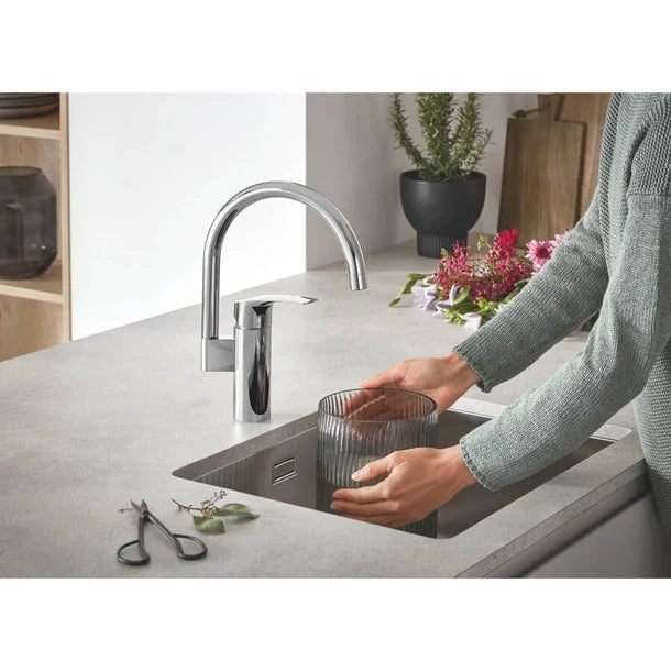 Moderne GROHE Eurosmart keukenkraan met draaibare hoge C-uitloop, geïnstalleerd op spoelbak – OnlineGo.nl